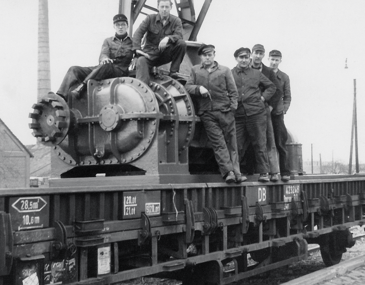 Fotografía de unos empleados sentados en una soplante de desplazamiento positivo enviada a Berlín por ferrocarril.